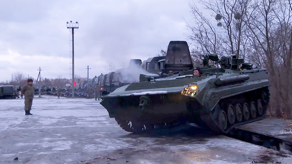 Russian troops unloading tanks from a train after arriving in Belarus