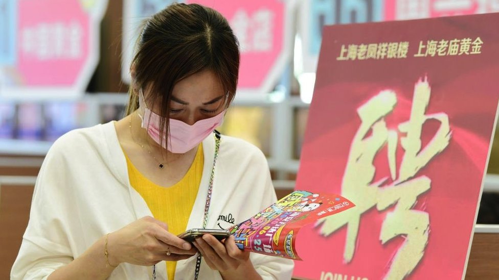 A woman checking information on her phone during a job fair in Hai'an City, Jiangsu Province, China, in May 2020