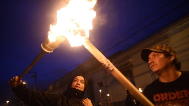 Manifestantes prendiendo una antorcha en Ciudad de Guatemala