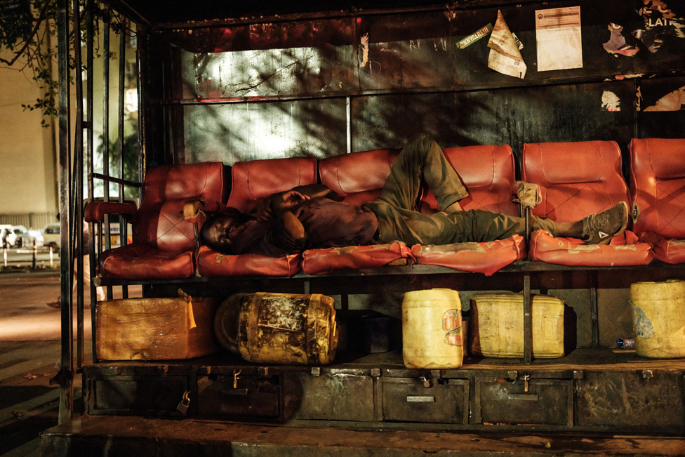 رجل ينام على كراسي مخصصة لتلميع الأحذية في نيروبي