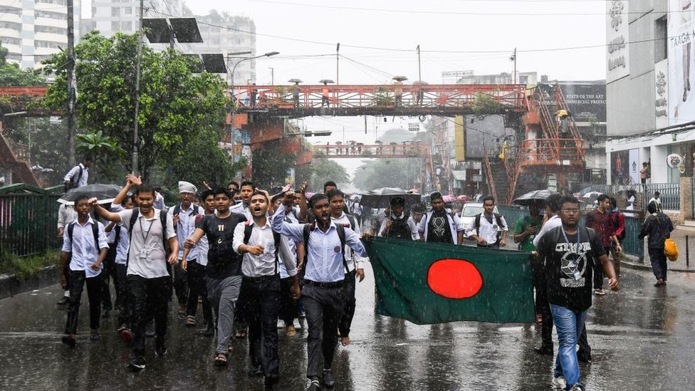 Grupo de estudiantes bajo la lluvia en una manifestación en la capital de Bangladesh, Daca.