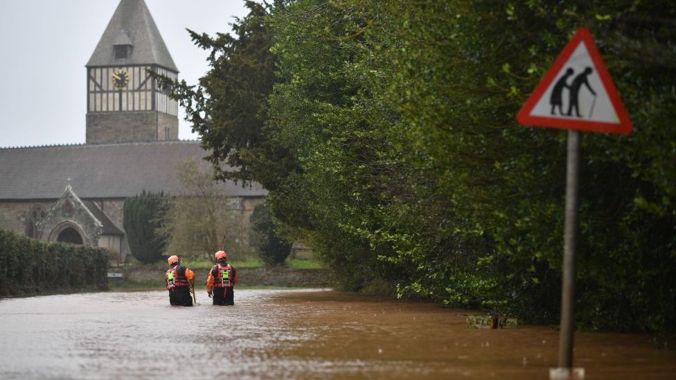 Пожарные и спасательные службы Херефорда проверяют глубину паводковой воды, когда они идут по затопленной дороге в деревне Хэмптон-Бишоп в Херефордшире, западная Англия, 20 февраля 2020 г.