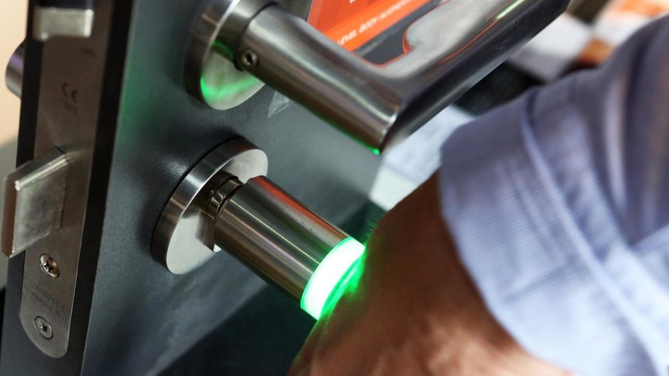 Los implantes de microchip pueden ser utilizados para actividades cotidianas, como desbloquear un telefóno o abrir una puerta en un edificio de oficinas. Una persona poniendo su brazo contra un lector de microchips