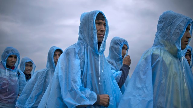 Migrants in rain coats