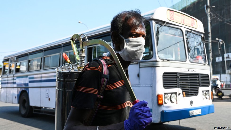 A worker sprays disinfectant to sanitize a bus station