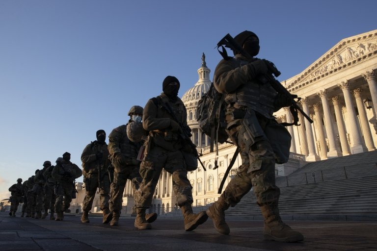 Soldiers walk in a line outside the US Capitol