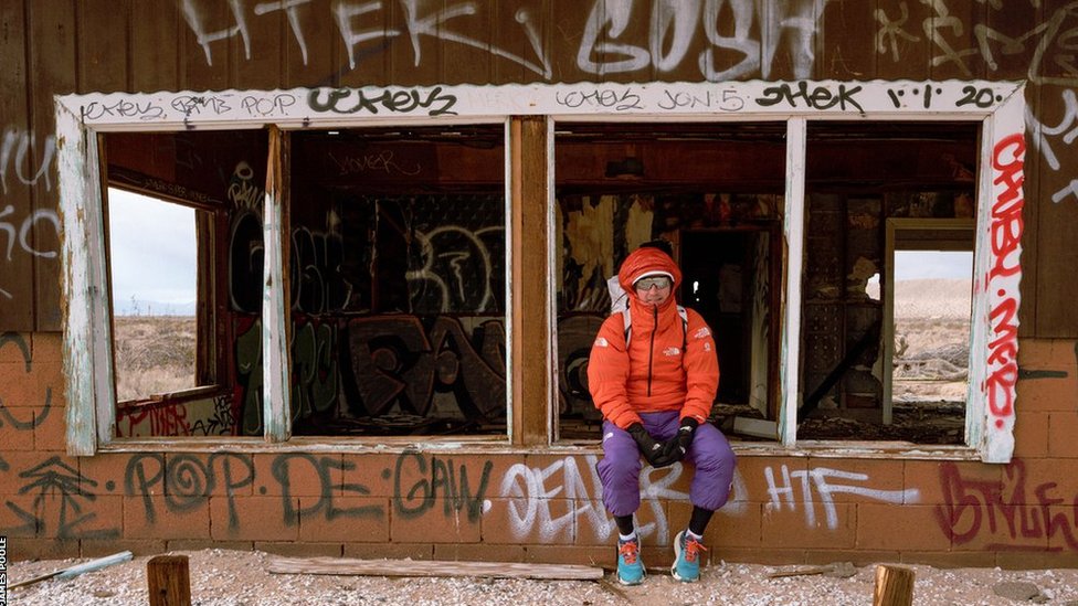 James Poole sentado frente a un edificio abandonado durante la carrera The Speed Project de 2023