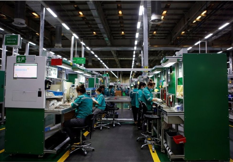 北京施耐德電氣工廠，員工在生產線上工作。