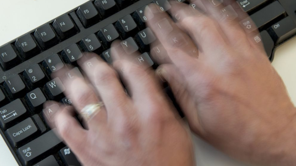 Una persona tipeando en un teclado.
