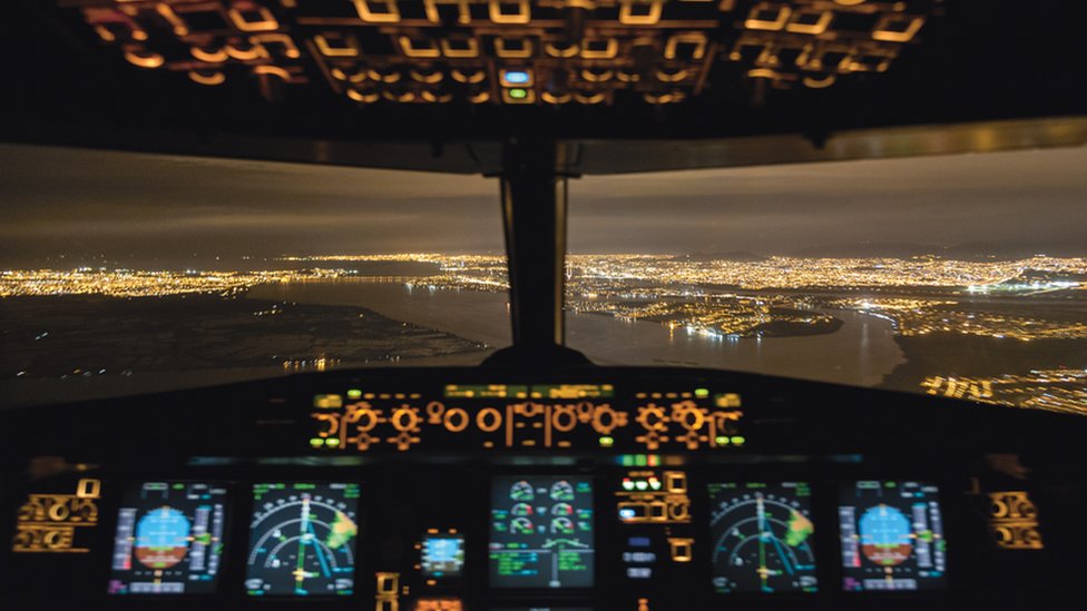 Las luces de una ciudad vista desde la cabina del avión que vuela Santiago Borja