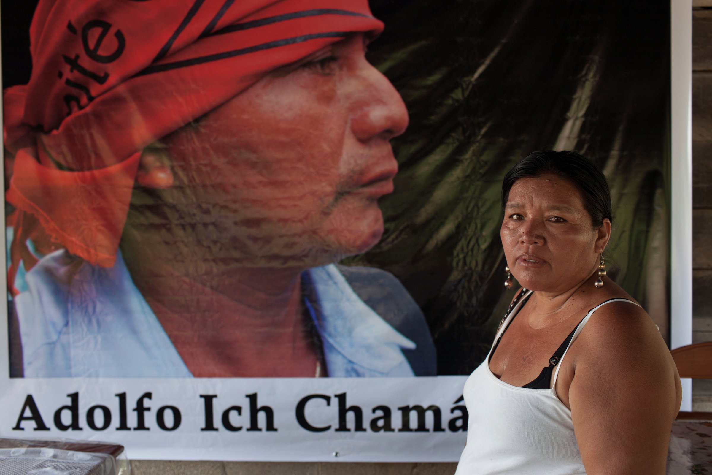 Анжелика Чок стоит перед знаменем с изображением своего убитого мужа, бывшего лидера общины майя Кекчи, учителя и борца за горнодобывающую деятельность Адольфо Ич
