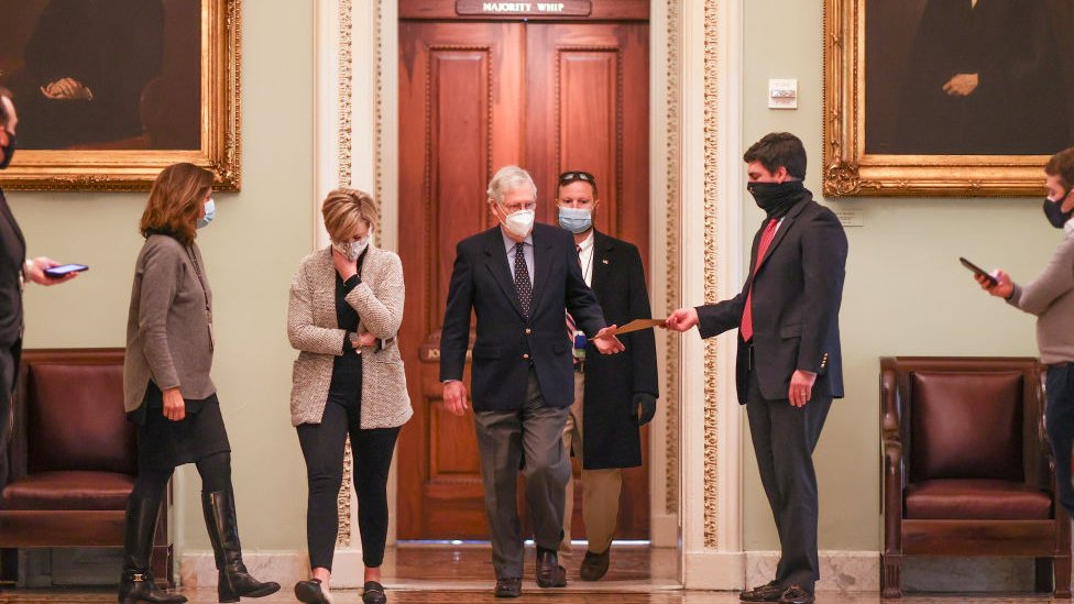 Mitch McConnell (C) heading for the Senate floor on Tuesday