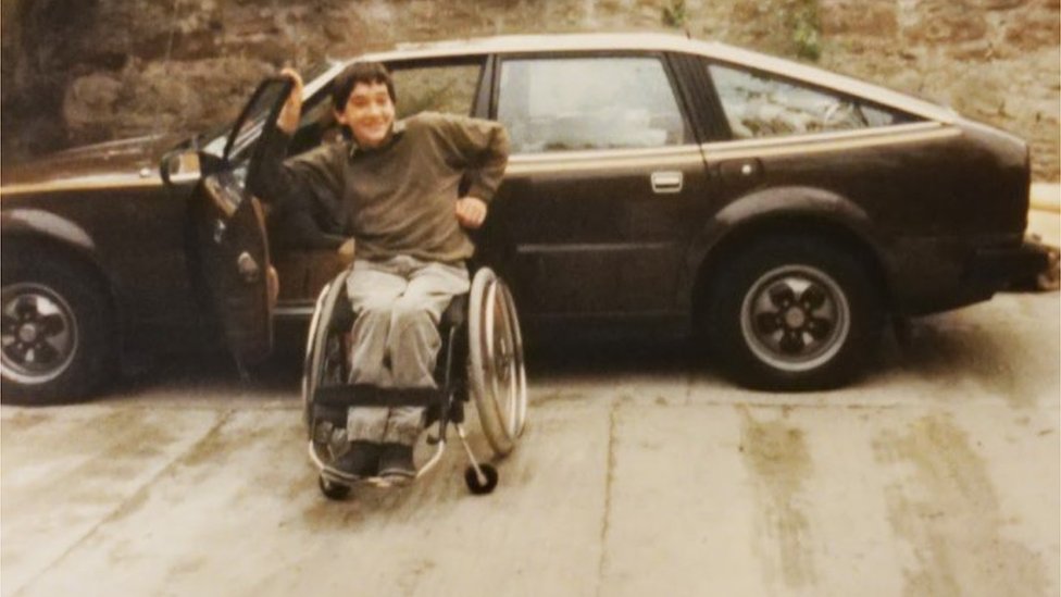 Эндрю в своем инвалидном кресле подростком в 1980-е