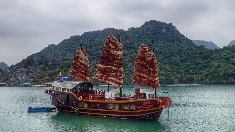 Navio chinês no mar, com serra atrás