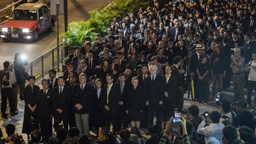 Юристы и студенты-юристы принимают участие в молчаливом марше протеста против решения Китая, которое фактически запрещает два законодателя, выступающих за независимость, вступят в должность в Гонконге 8 ноября 2016 г.