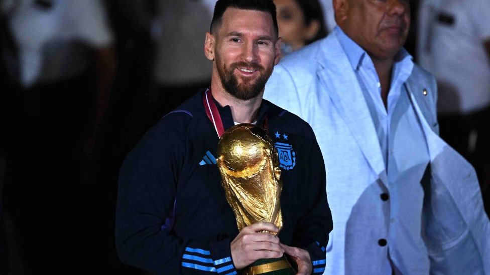 Messi sosteniendo la copa en su llegada a Argentina.