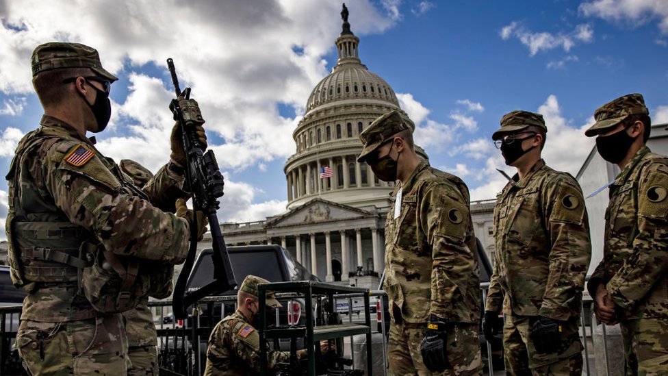 National Guard troops take up weapons as they guard the US Capitol after rioters attacked the building January 2021