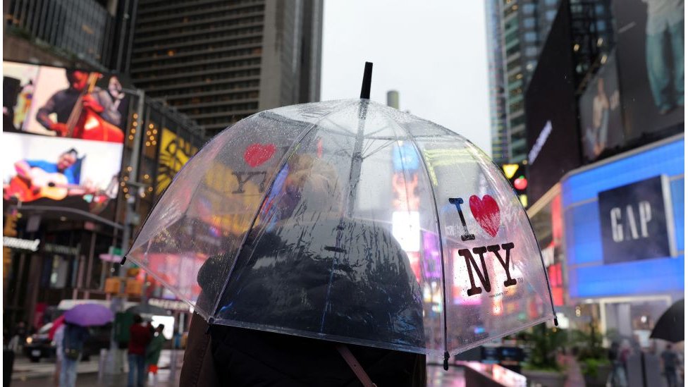 Osoba sa kišobranom na kome piše "Volim Njujork"