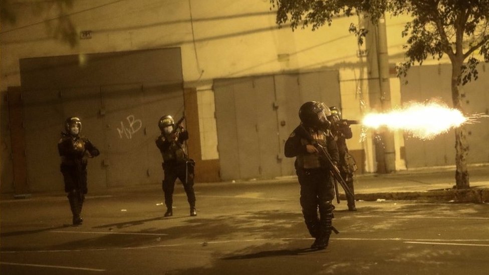 Policías disparando gases lacrimógenos contra los manifestantes.