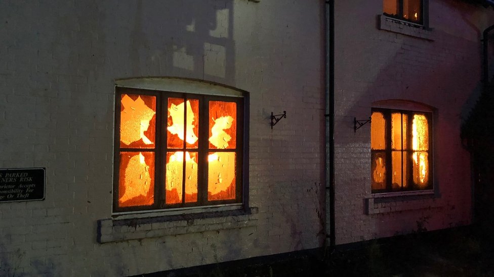 Пламя видно сквозь окна паба