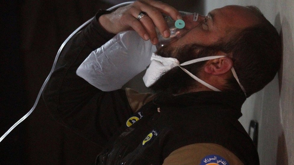 Сотрудник службы гражданской обороны дышит через кислородную маску после предполагаемой газовой атаки в городе Хан-Шейхун в удерживаемом повстанцами Идлибе, Сирия, 4 апреля 2017 г.