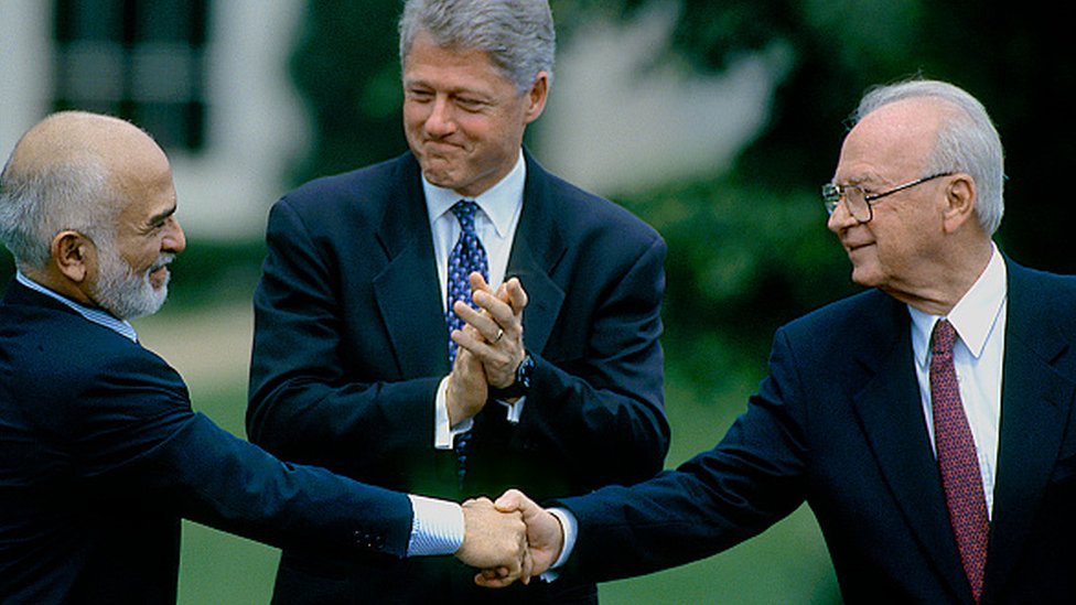 1994'te ABD'nin öncülük ettiği İsrail-Ürdün barış görüşmeleri sırasında dönemin ABD Başkanı Bill Clinton'ın yanında Ürdün Kralı 1. Hüseyin, İsrail Başbakanı İzhak Rabin'le el sıkışıyor.
