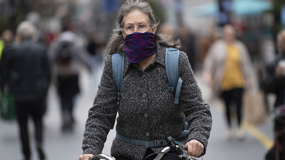 woman on bike wearing mask
