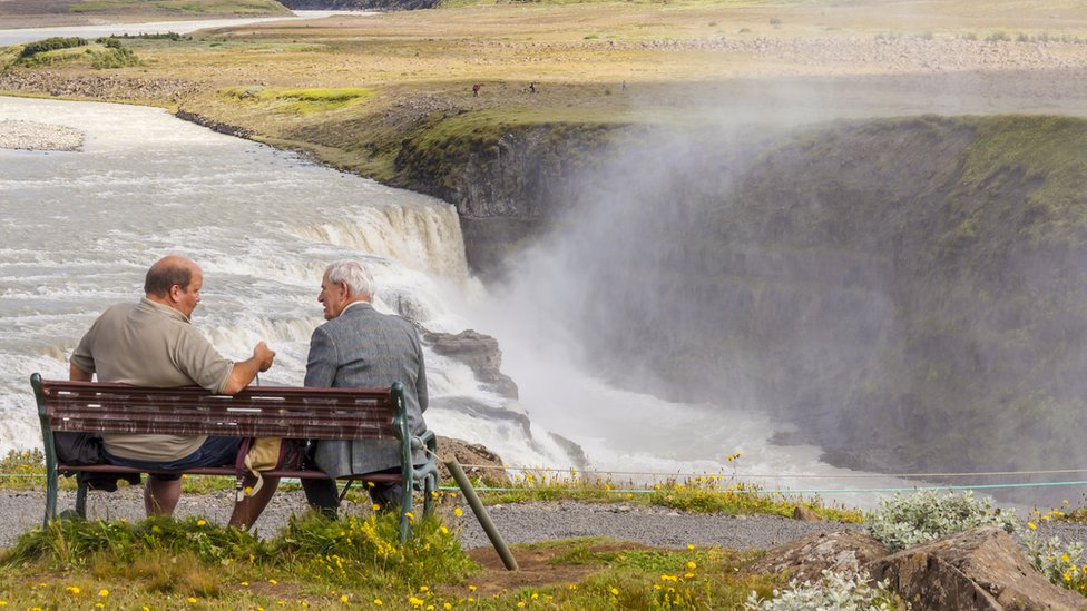El islandés es una de las lenguas del mundo amenazadas por la tecnología. Dos hombres conversando en un banco de Islandia.