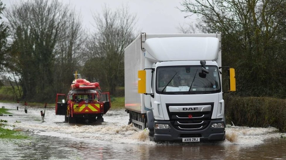 Херефордская служба пожарно-спасательной службы проверяет глубину паводковой воды в деревне Хэмптон-Бишоп в Херефордшире, западная Англия