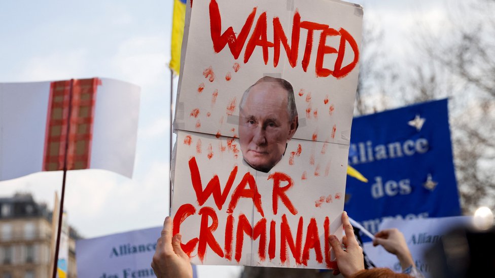 Paris'te bir protestoda Vladimir Putin'in savaş suçu işlediğini söyleyen pankart