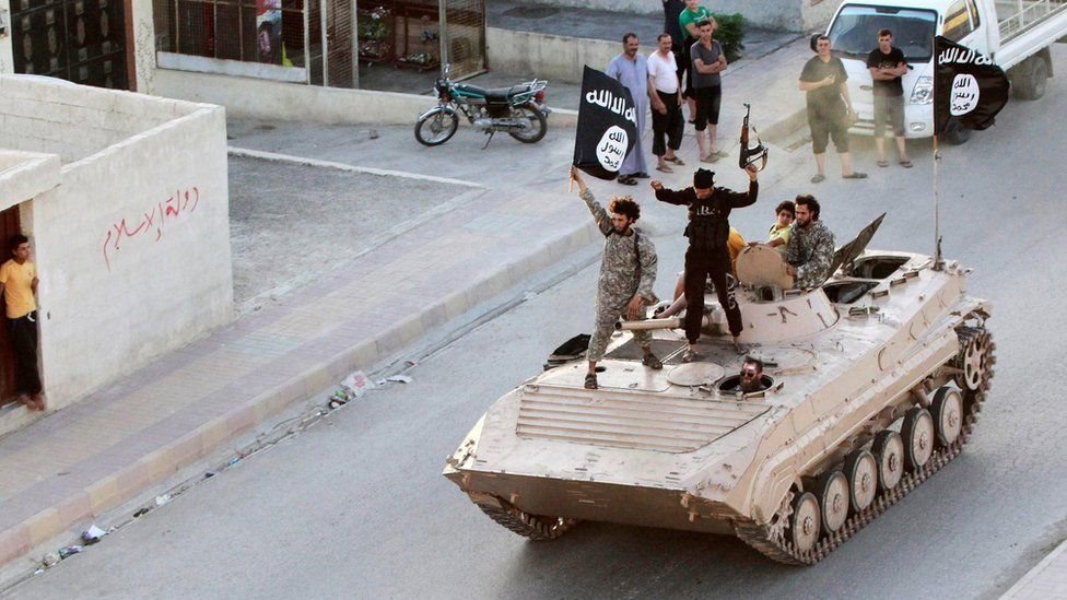 مقاتلون من تنظيم الدولة الإسلامية فوق دبابة