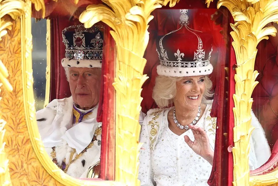 الملك تشارلز والملكة كاميلا في العربة المذهبة بعد الخروج من دير وستمنستر أبي في غولد ستيت كوتش