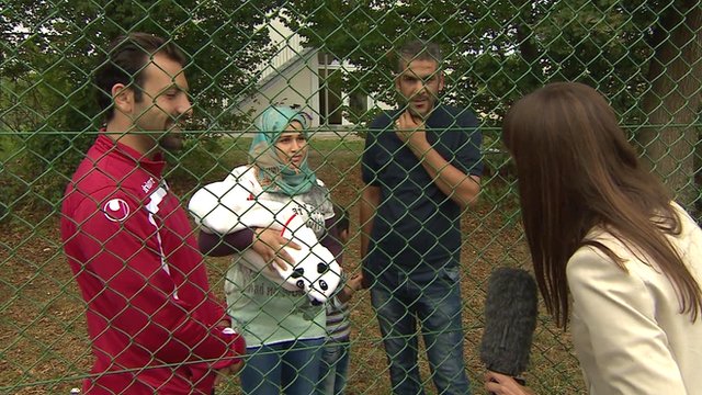 The BBC's Jenny Hill (far right) speaks to a family from Syria in Germany