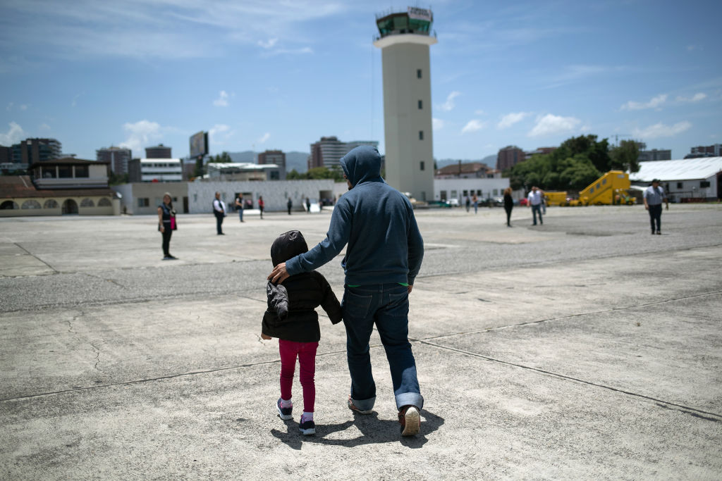 Un padre camina junto a su hija en el aeropuerto de Brownsville, TX, rumbo a un vuelo de deportación.