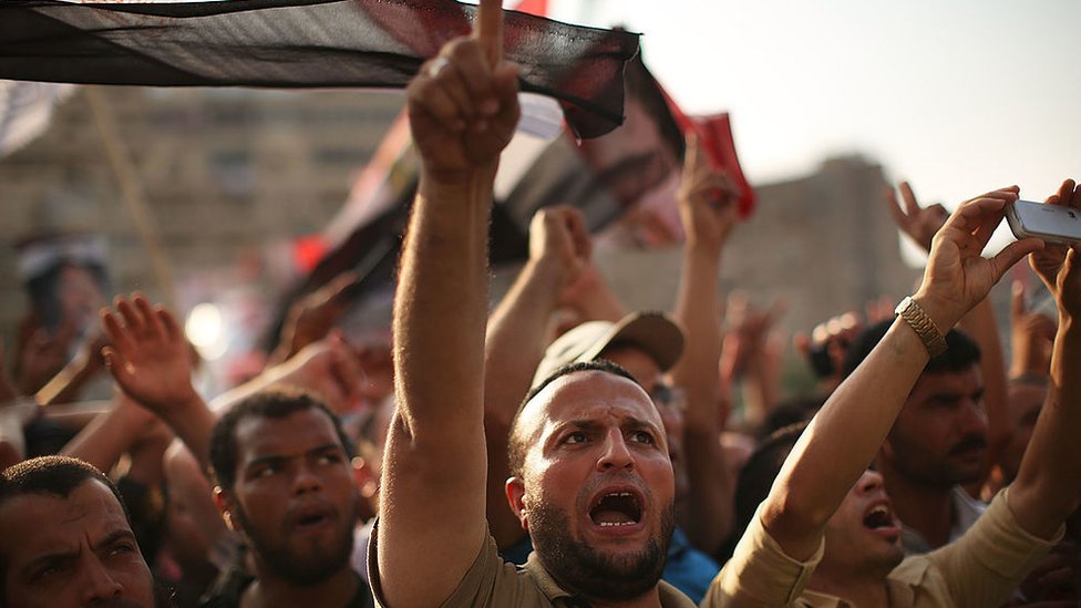 Сторонники Pro Mohammed Morsi проводят митинг рядом с местом, где более 50 якобы были убиты сотрудниками египетских вооруженных сил и полиции в ходе столкновений ранним утром 8 июля 2013 года в Каире, Египет.