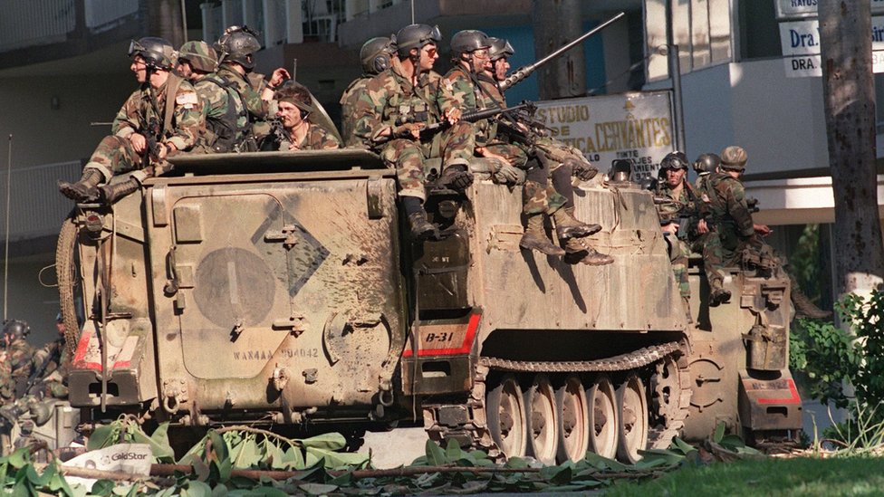 Американские солдаты сидят на бронетехнике на улице Панама-Сити во время операции «Правое дело» 23 декабря 1989 г.