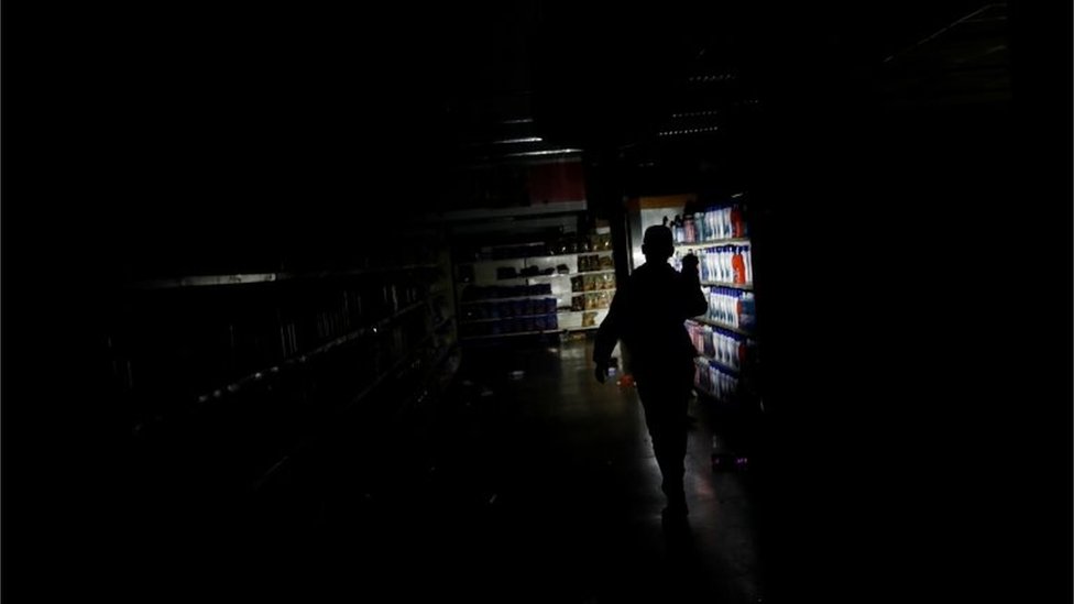El trabajador de un supermercado inspecciona los daños causados a una tienda saqueada en Caracas.