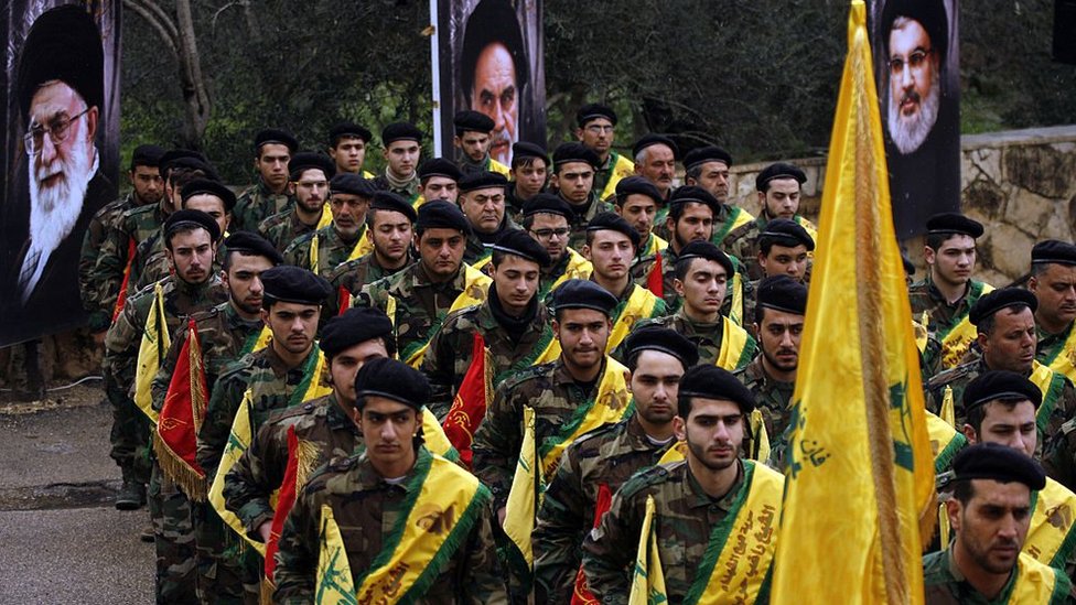 Hezbollah fighters march near portraits of Iranian and Hezbollah leaders (file photo)