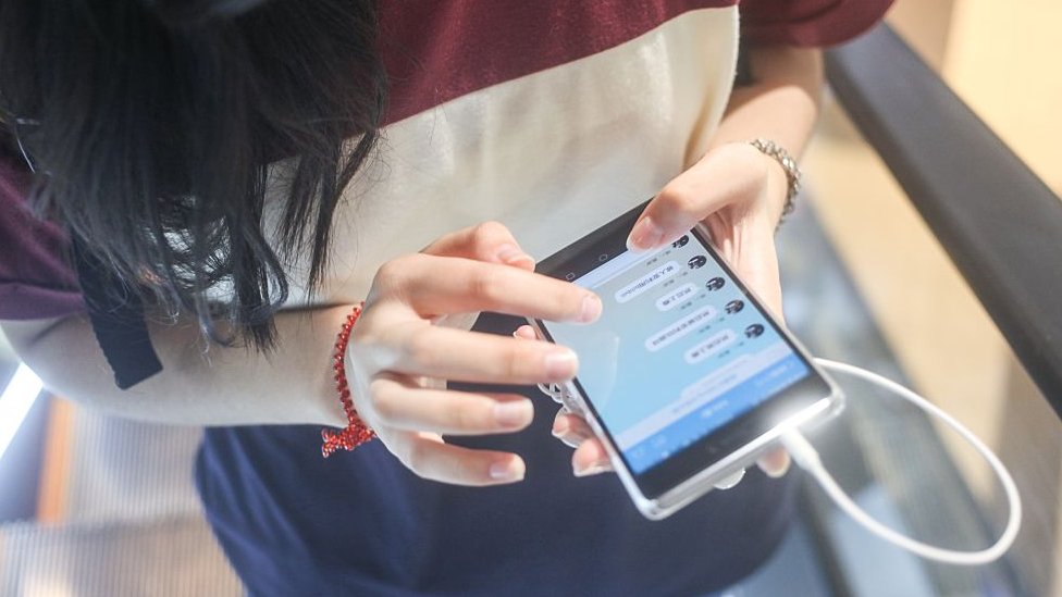 Se ha convertido en la aplicación de aplicaciones de moda en China. joven china usando WeChat