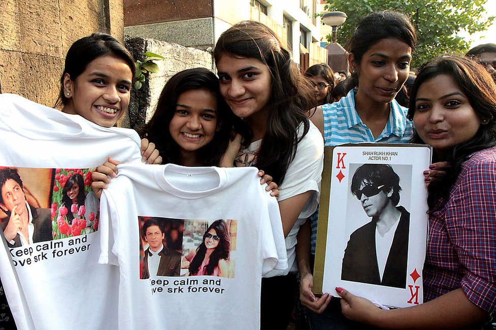 Para penggemar berpose dengan potret aktor Bollywood Shah Rukh Khan pada perayaan ulang tahunnya yang ke-48 di luar tempat tinggalnya di Mumbai pada 2 November, 2013.