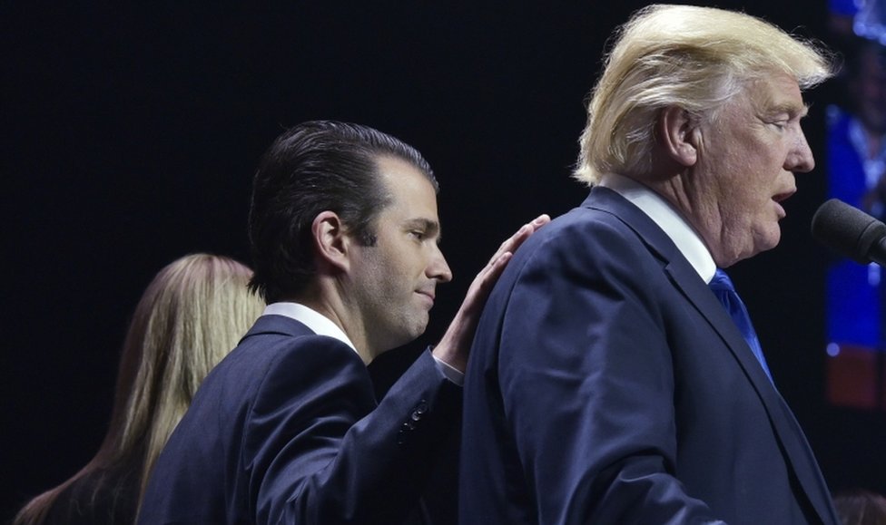 Дональд Трамп-младший кладет руку на плечо своего отца, Дональда Трампа, во время митинга в последнюю ночь президентских выборов в США в 2016 году