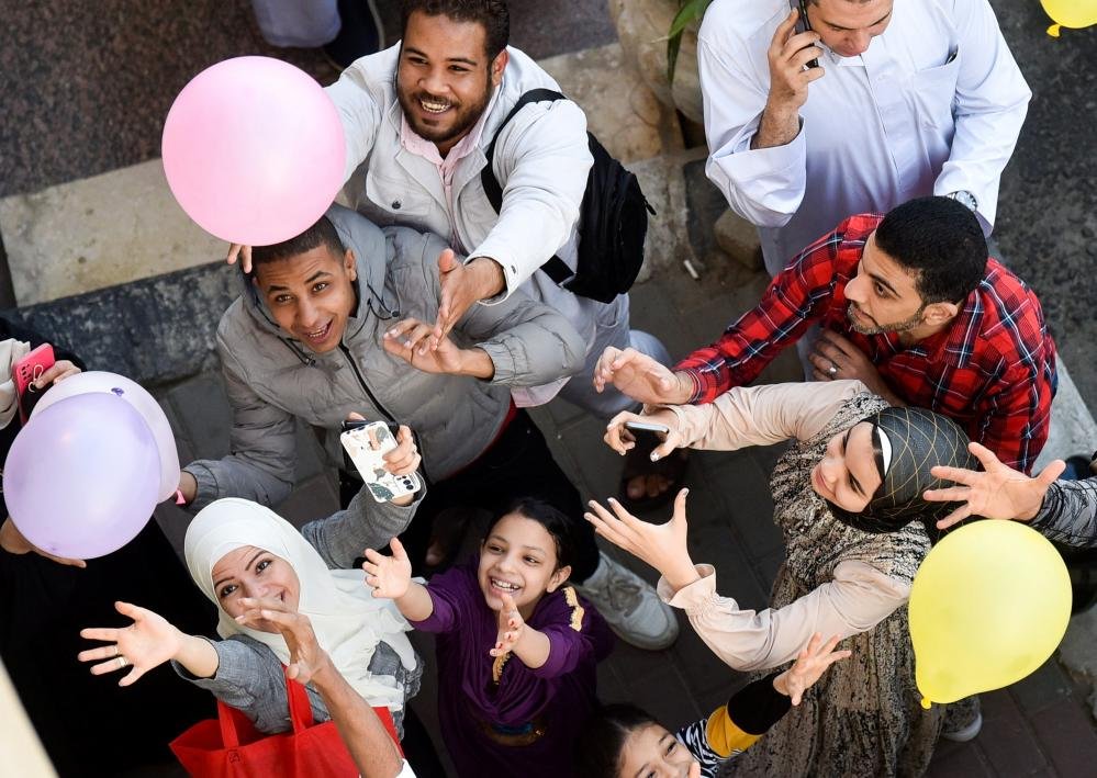 أشخاص يحاولون التقاط البالونات في القاهرة