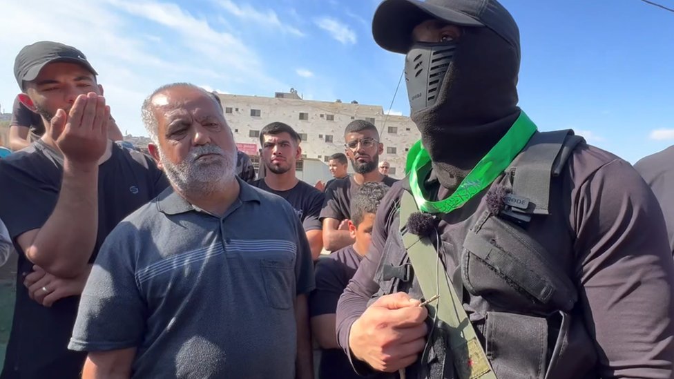 Borac Hamasa govori za BBC dok muškarci posmatraju