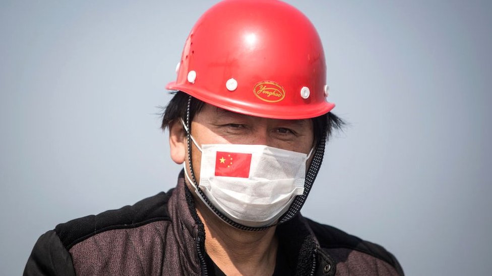 Капитан в маске на корабле в контейнерном порту Янлуо в Ухане, провинция Хубэй, Китай.