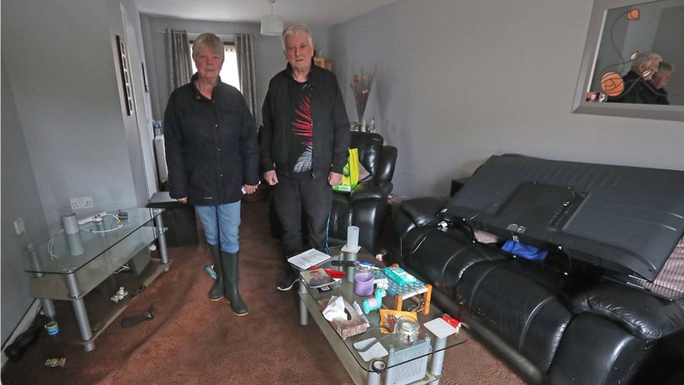 Джин Хендри и Уильям Крейк убирают свой дом в Пиотхолл-Корт в Броксберне, Западный Лотиан после наводнения.