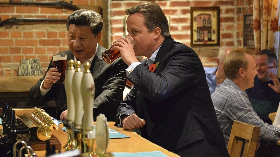 China's President Xi Jinping and then-UK Prime Minister David Cameron share a pint at a pub in 2015.