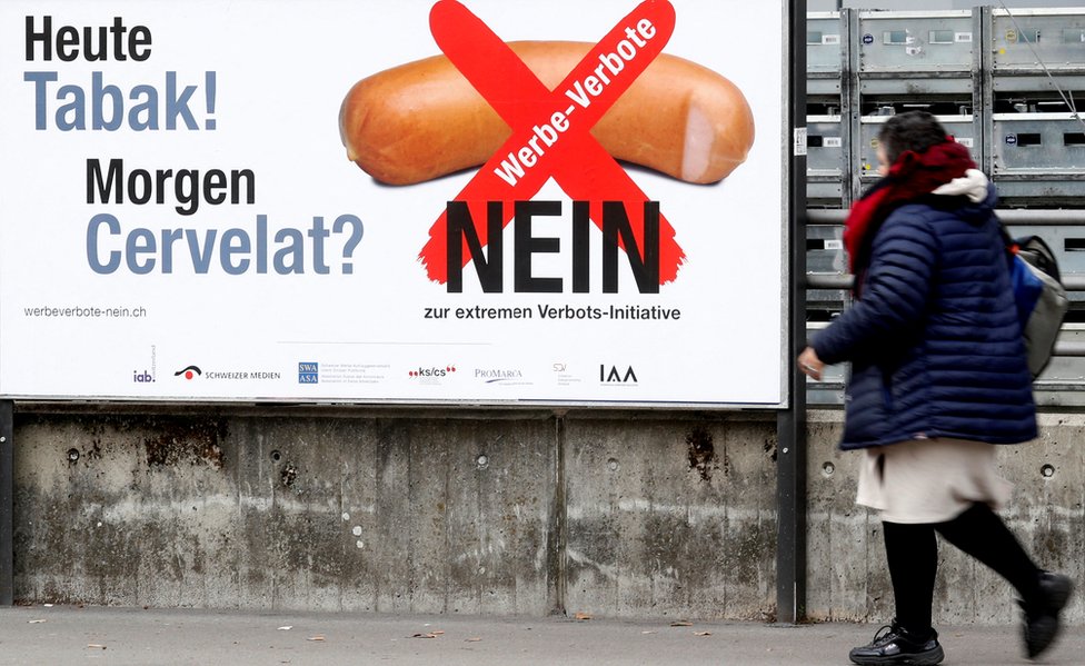 لافتات معارضة للحظر تحمل عبارة "اليوم السجائر، غدا النقانق" - في استفتاء سويسرا