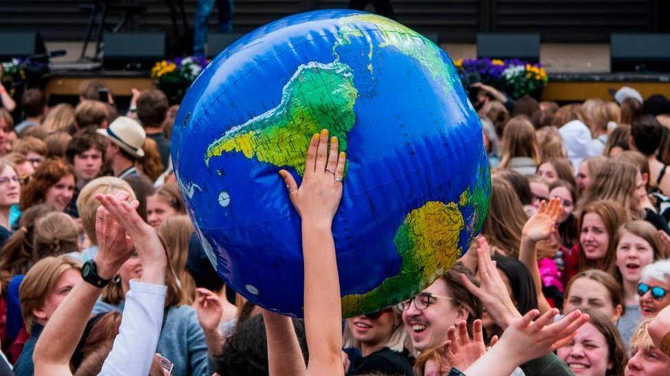 Grupa mladih drži naduvani globus