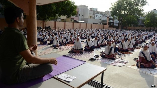 Индийские школьники посещают семинар по йоге, проводимый учителями Института Шри Шри Рави Шанкара в Высшей средней школе FD в Ахмедабаде, 16 июня 2015 г.