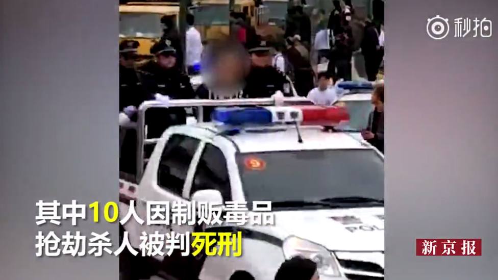 Los convictos fueron paseados en la parte trasera de autos de la policía antes de su ejecución "inmediata". Foto: Beijing News. Persona condenada en la parte trasera de un auto de la policía